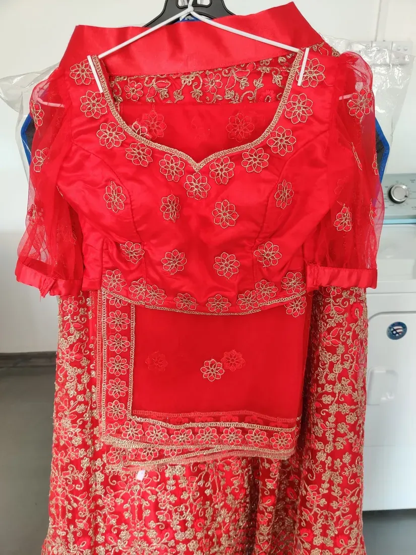Embroidered red saree and lehenga cleaned and wrapped at Champion Laundry